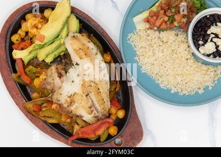 Blick von oben auf die Fajitas-Platte mit Meeresfrüchten und großem gegrilltem Filet auf Gemüse und Schalentieren. Stockfoto