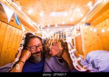 Junge glückliche Erwachsene haben Spaß zusammen auf dem Bett liegen In einem klassisch restaurierten Holztransporter genießen Reise Lifestyle Urlaub - Mann und Frau innen roman Stockfoto