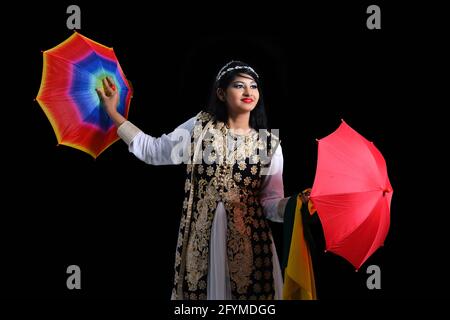 Zauberer macht Tricks mit Regenschirmen auf schwarzem Hintergrund Stockfoto