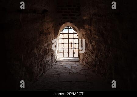 Fenster mit Balken in der alten Festung, dunkler architektonischer Hintergrund Stockfoto