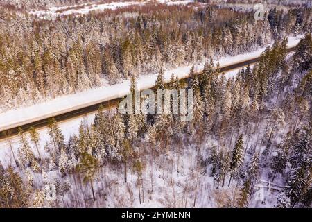 Direkte Straße durch den Winterwald. Blick von oben Stockfoto