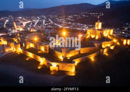 Malerischer Blick von der Drohne auf das ummauerte alte Schloss Akhaltsikhe Rabati mit der Ahmediye-Moschee in hellen Lichtern auf dem Hintergrund mit beleuchtetem Stadtbild Stockfoto