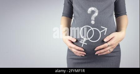 Mittelteil einer Schwangeren, die den Bauch mit einem Hologramm-Fragezeichen auf grauem Hintergrund berührt. Nahaufnahme, Kopierbereich. Stockfoto