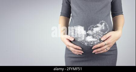 Eine Schwangerin berührt ihren Bauch mit einem Hologramm-Mutterleib. Muttervorfreude Schwangerschaft, Mutterschaftskonzept. Stockfoto