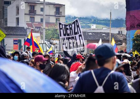 Pasto, Kolumbien. Mai 2021. Ein Demonstrator hebt ein Zeichen auf, das „Stärke des Volkes“ lautet, während Kolumbien den ersten Monat der regierungsfeindlichen Proteste gegen die Steuerabgaben und Gesundheitsreformen von Präsident Duque sowie die Brutalität und Unruhen der Polizei feiert, überschwemmen Tausende am 28. Mai 2021 die Straßen von Pasto, Narino, Kolumbien. Kredit: Long Visual Press/Alamy Live Nachrichten Stockfoto