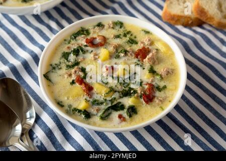 Hausgemachte Zuppa Toscana mit Kale und Brot in einer weißen Schüssel, Seitenansicht. Stockfoto