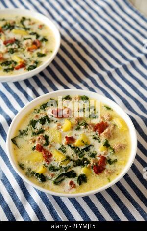 Hausgemachte Zuppa Toscana mit Kale und Brot in einer weißen Schüssel, Seitenansicht. Stockfoto