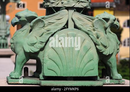 Grüne Gripins oder Gryphons mit geschwungenen Adlerschnäbeln unterstützen die Lampenstandards entlang der Balustraden der Drachenbrücke, die den Fluss Ljubljanica in Ljubljana, Slowenien, überspannt – Begleiter von vier furchterregend aussehenden und viel größeren grünen Kupferdrachen, die die vier Ecken der Struktur bewachen. Die Brücke wurde nach Entwürfen des dalmatinischen Architekten und Ingenieurs Jurij Zaninović (1876-1946) im Jugendstil / Wiener Secession erbaut und 1901, als Ljubljana eine Stadt im österreichisch-ungarischen Kaiserreich war, für den Verkehr geöffnet. Stockfoto