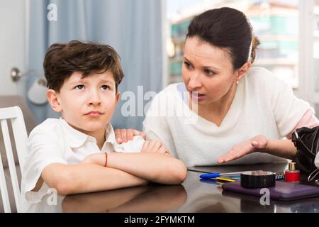 Portrait des gestörten jugendlich Junge und seine Mutter ihn schimpfen in Home Interior Stockfoto