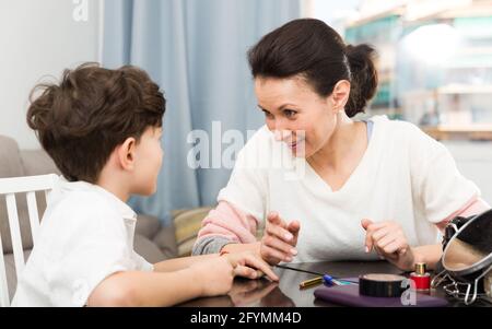 Portrait von glücklichen Frau mit freundlichen Unterhaltung mit ihrem jugendlichen Sohn zu Hause Stockfoto