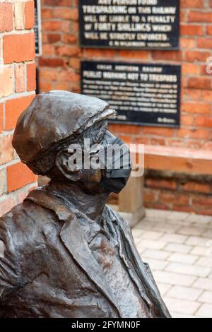 Der Mann auf der Bank am Bahnhof Irlam Stockfoto