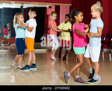 Lächelnde Kinder Grundschule versucht Tanz der Partner Tanz in modernen Tanzstudio Stockfoto
