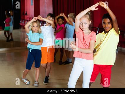 Lächelnd fröhlich positive Kinder Grundschule versuchen, tanzen Salsa Tanz in modernen Studio Stockfoto