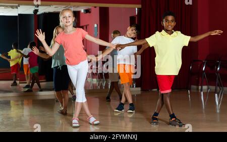 Lächelnde Kinder versuchen, tanzenden Partner tanzen in modernen Studio Stockfoto