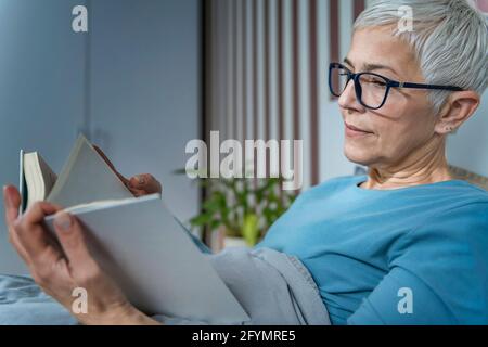 Frau im Bett lesen Stockfoto