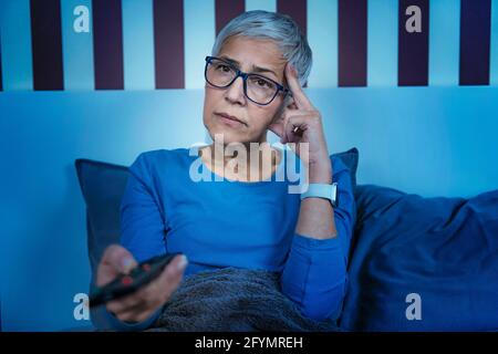Frau mit Schlaflosigkeit beim Fernsehen Stockfoto