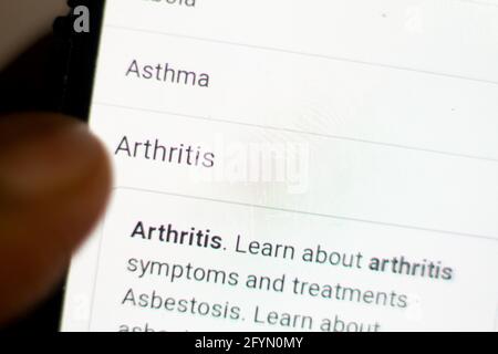 Arthritis News.Nachrichten auf dem Handy.Handy in den Händen. Selektiver Fokus und chromatische Aberration Effekte. Stockfoto