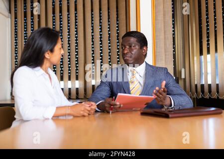 Geschäftsmann und Geschäftsfrau kommunizieren und unterzeichnen Dokumente am Verhandlungstisch im Büro Stockfoto