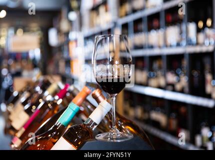 Rotweinprobe Glas vor verschwommenem Hintergrund des Weinhauses Interieur Stockfoto