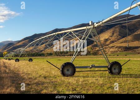 Ein Center Pivot Farm Bewässerungssystem, das sich bis in die Ferne erstreckt. Fotografiert in der Region Otago auf der Südinsel Neuseelands Stockfoto