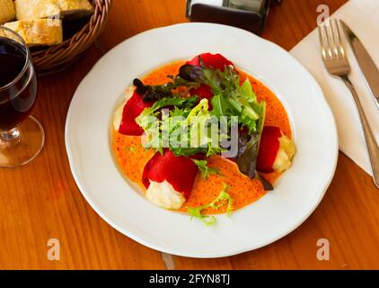 Leckere gefüllte Piquillo-Paprika mit Kabeljau-Brandade in Sauce mit Salat Stockfoto