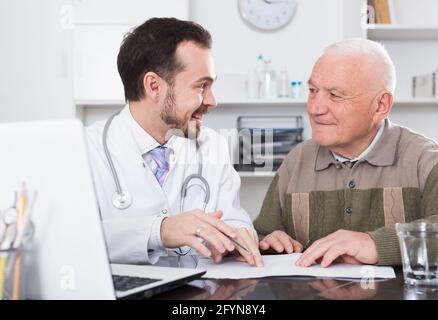 Alter Mann in Absprache mit Mann Arzt im Krankenhaus Stockfoto