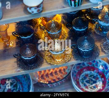Auswahl an traditionellen, farbenfrohen, handgefertigten Tee- und Kaffeetassen in den Regalen des türkischen Souvenirshops Stockfoto