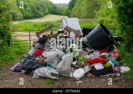 Coleshill, Buckinghamshire, Großbritannien. Mai 2021. Ein Landwirt konnte heute Morgen nicht auf sein Land zugreifen, da über Nacht ein großer Haufen Haushaltsmüll geflogen worden war, darunter Post von einer Adresse in der Streatham Road, London. Während der Pandemie von Covid-19 hat es in Buckinghamshire einen enormen Anstieg der illegalen Fliegenkippung gegeben, obwohl die Abfallentsorgungsstellen für den Handel geöffnet waren. Das Kippen von Fliegen ist eine Straftat, die mit einer Geldstrafe von bis zu £50,000 oder 12 Monaten Freiheitsstrafe vor einem Amtsgericht geahndet werden kann. Die Straftat kann eine unbegrenzte Geldstrafe und bis zu 5 Jahren Gefängnis anziehen, wenn sie in einem Crown Cou verurteilt wird Stockfoto