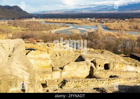 Blick von der Höhlenstadt Uplistsikhe auf den Fluss Kura und das Stadtbild von Gori am Ufer des Flusses am sonnigen Frühlingstag, Georgia Stockfoto