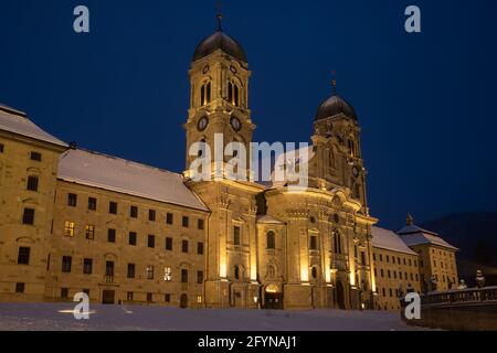 Die Benediktinerabtei Einsiedeln mit ihrer mächtigen Basilika ist das wichtigste katholische Wallfahrtszentrum der Schweiz. Weihnachtszeit, schneebedeckter Winter und b Stockfoto