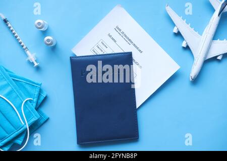 Pass, Impfkarte, Handdesinfektionsmittel und Maske auf farbigem Hintergrund Stockfoto