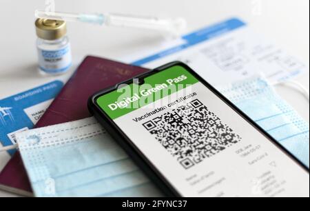 ZAGREB, KROATIEN - 21. Mai 2021: Coronavirus Passreisekonzept. Nahaufnahme des digiralen grünen Zertifikats auf dem Mobiltelefon, das über einem chirurgischen Eingriff liegt Stockfoto
