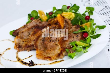 Gegrilltes Schweinefleisch Rib Steak auf dem weißen Teller chop serviert mit mash Salat, Avocado und Preiselbeeren Stockfoto