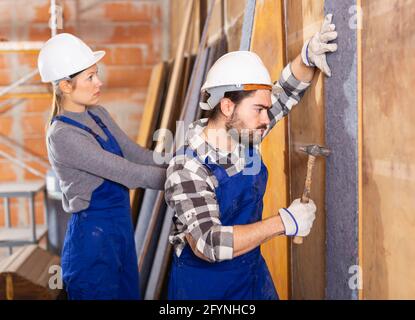 Zwei professionelle Bauherren scheide Wände mit Isolierung Stockfoto