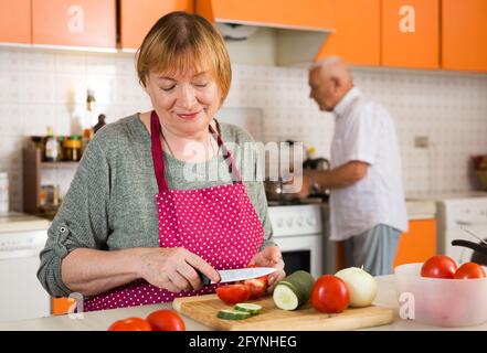 Fröhliches Senior-Paar Kochen zusammen in der Küche Stockfoto