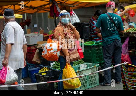 (210529) -- KUALA LUMPUR, 29. Mai 2021 (Xinhua) -- EINE Frau, die eine Gesichtsmaske und einen Gesichtsschutz trägt, kauft sich auf einem Markt vor einer Sperre in Kuala Lumpur, Malaysia, 29. Mai 2021. Malaysia meldete am Samstag Sprünge in der höchsten täglichen Rekordzeit von neuen COVID-19-Fällen und Todesfällen, nachdem die Regierung eine totale Sperrung angekündigt hatte, um den Ausbruch einzudämmen. Es wurde ein neues Tageshoch von 9,020 Infektionen gemeldet, ein Anstieg gegenüber dem vorherigen Höchstwert von 8,290 Fällen, der vor einem Tag verzeichnet wurde, was die nationale Gesamtzahl auf 558,534 erhöht, so das Gesundheitsministerium. Quelle: Xinhua/Alamy Live News Stockfoto