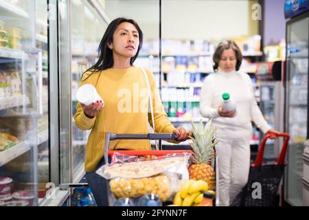 Weibliche Shopper wählt Milchprodukte im Supermarkt Stockfoto