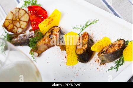 Fischgericht: Auf dem Teller werden köstliche gebackene Forellensteaks mit Kartoffeln und Kräutern serviert Stockfoto