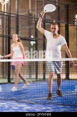 Fokussierter Mann, der auf einem kleinen geschlossenen Platz ein freundliches Paddle-Ball-Spiel spielt. Konzept der Konzentration im Wettbewerb Stockfoto