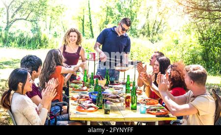 Fröhliche Freunde, die gemeinsam auf der Barbecue-Picknick-Party Spaß haben - Jugendliche Millennials bei pic nic auf dem Open-Air-Festival - Jugendfreundschaftskonzept Stockfoto