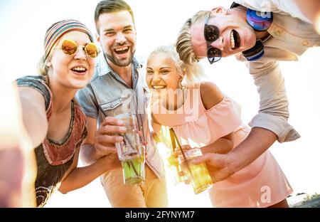 Happy Millenial friends Group macht Selfie auf einer lustigen Strandparty Cocktails trinken bei Sonnenuntergang - Sommer Freude und Freundschaft Konzept mit jungen Menschen Stockfoto