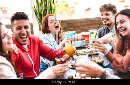 Freunde toasten nach der Arbeit im Open Air Bar Restaurant bunte Getränke - Life Style Konzept mit Leuten, die Spaß haben, Cocktails zu teilen Stockfoto
