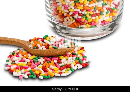 Regenbogen streut in transparentem Glas und in Holzlöffel isoliert auf weißem Hintergrund mit Clipping Pfad. Stockfoto