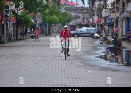 Assam. Mai 2021. Ein Mann mit Gesichtsmaske fährt während einer Sperre im Nagaon-Distrikt im nordöstlichen indischen Bundesstaat Assam, 29. Mai 2021, auf einem geschlossenen Markt mit dem Fahrrad. Indiens COVID-19-Quote erreichte am Samstag 27,729,247, wobei in den letzten 24 Stunden 173,790 neue Fälle hinzukamen, sagte das Bundesgesundheitsministerium. Quelle: Str/Xinhua/Alamy Live News Stockfoto