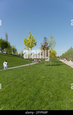 Krasnodar, Russland-02. Mai 2021: Die Menschen entspannen sich und wandern auf den Wegen im beliebten Krasnodar Park unter den Stadtbewohnern. Frische Frühlingsgrüns der Natur Stockfoto