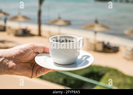 Mann hält eine Tasse Kaffee. „Guten Morgen, Sonnenaufgang“-Konzept. Beginnen wir einen neuen Tag. Platz für Text Stockfoto