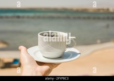 Weibliche Hände halten eine Tasse Kaffee. „Guten Morgen, Sonnenaufgang“-Konzept. Beginnen wir einen neuen Tag. Platz für Text Stockfoto