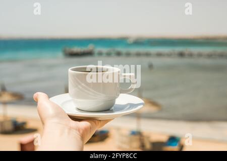 Weibliche Hände halten eine Tasse Kaffee. „Guten Morgen, Sonnenaufgang“-Konzept. Beginnen wir einen neuen Tag. Platz für Text Stockfoto