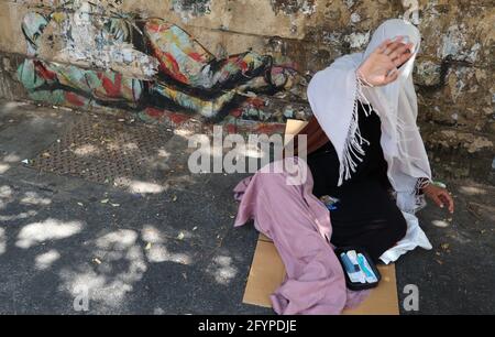 Syrische Frau bettelt in der Hamra Street, Downtown Beirut, 29. Mai 2021 nach Angaben des UNHCR hat der syrische Krieg dem Libanon, der vor einer tiefen Wirtschafts- und Finanzkrise, der COVID-19-Pandemie und der verheerenden Explosion im Hafen von Beirut im August 2020 steht, einen hohen wirtschaftlichen und sozialen Tribut auferlegt. Die langwierige Situation der Flüchtlinge in einem Kontext mit begrenzten Selbständigkeit, gepaart mit den Auswirkungen dieser jüngsten Krisen, haben zu einem exponentiellen Anstieg extremer Armut unter der syrischen Bevölkerung im Land geführt. (Elisa Gestri/Sipausa) Stockfoto