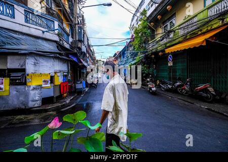 Ein älterer Mann geht auf einer schmalen Straße in Talat Noi, Bangkok, Thailand Stockfoto